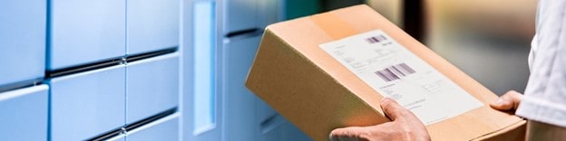 Man delivering package to business and dropping off at smart locker with cardboard box in hand