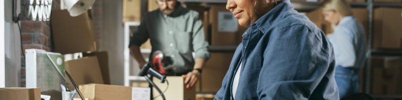 Woman scanning outgoing packages in her mail center using Brynka's Multi-Carrier Desktop Shipping platform